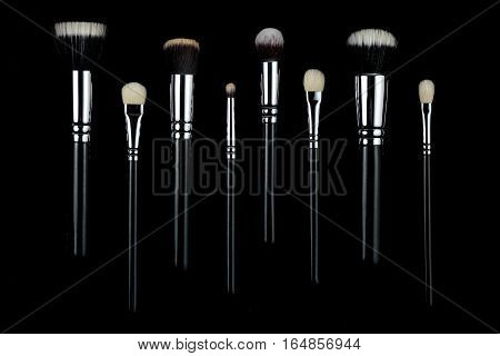 Makeup brushes lying on a black background