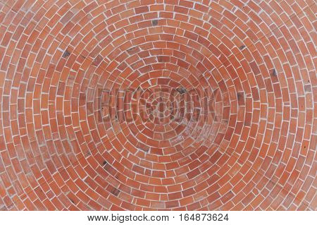 Round stone pavement pattern. Top view of red bricks circular pavement texture