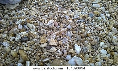 Beautiful background: marine wet pebbles of different sizes on the shore
