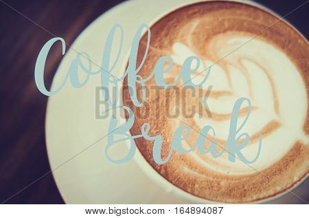 hot milk art coffee on wooden table with qoute on photo