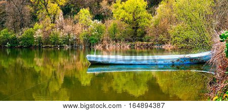 Lonely boat on spring lake, Rusenski Lom park, Ruse district, Bulgaria.