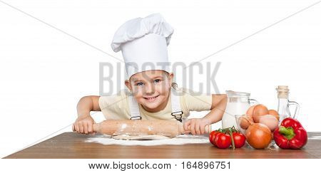 Happy little chef smeary with flour stretching the dough