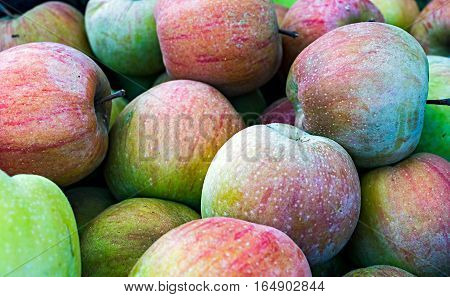 A pile of apples at a farmers market.