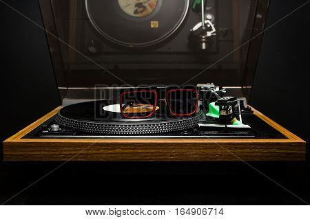 Vintage 1970s record player with a sunglasses over the acetate disc, Dj accessories