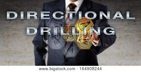 Industrial manager in blue business suit activating DIRECTIONAL DRILLING on an interactive computer screen. Oil and gas industry technology concept for non-vertical well drilling or slant drilling.