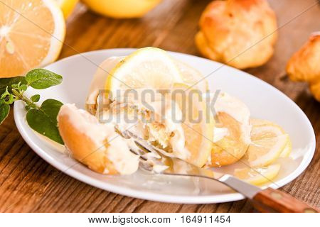 Lemon Profiteroles with custard cream on white dish.