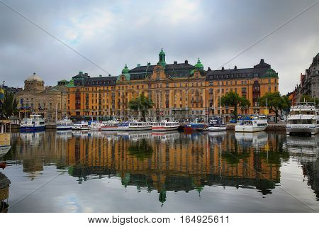 STOCKHOLM SWEDEN - AUGUST 20 2016: Many people walk and visit on Strandvagen street on Ostermalm distric with touristic sightseeing boats in Stockholm Sweden on August 20 2016.