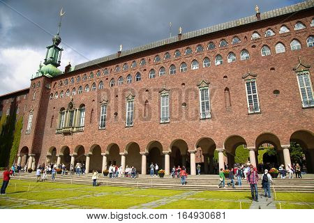 STOCKHOLM SWEDEN - AUGUST 19 2016: Tourists walk and visit Stockholm City Hall ( Stadshuset ) Venetian-style colonnade that divides the City Hall in Stockholm Sweden on August 19 2016.