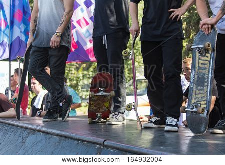 KAZAKHSTAN ALMATY - AUGUST 28, 2016: Urban extreme competition, where the city athletes compete in the disciplines: skateboard, roller skates, BMX. Bmx stunt performed at the top of a mini ramp on a skatepark.Winners team on the mountain top. Sport and ac