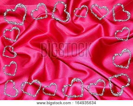 beautiful frame of brilliant hearts on a background of red silk