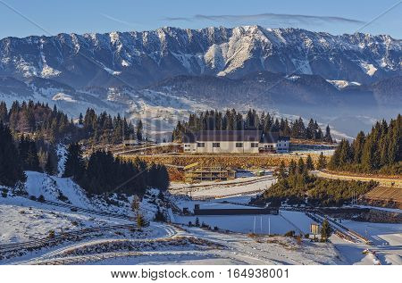 Panoramic view over the touristic ski resort Cheile Gradistei Fundata and the majestic snowy Piatra Craiului mountains range Romania.