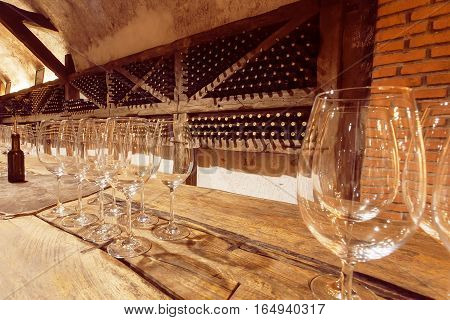 KVARELI, GEORGIA - OCT 3, 2016: Wine glasses on wooden table of the tasting room of old cellar Khareba Winery on October 3, 2016. The cellar tunnel was opened in 1962 for the World Wine Congress