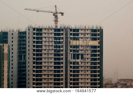 Under construction buildings with a crane and concrete structure in Noida Delhi Gurgaon. The surge in people living in these cities has led to huge construction projects