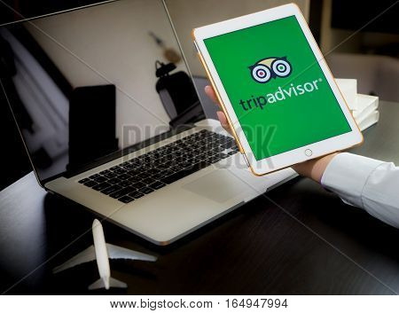 Bangkok, Thailand - December 14, 2016: Business man is using tripadvisor application to plan his trip.