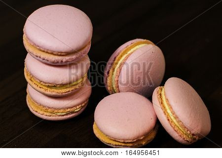 Freshly made pink french macarons on the tabke