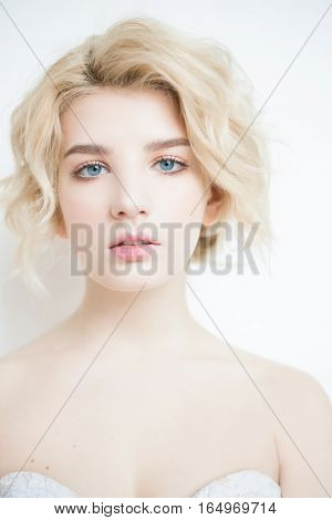 Woman with white hair in a wedding dress. Young blonde woman with blue eyes. Portrait of a beautiful blonde girl. Fashion model. Woman with perfect skin. Nude makeup. Fashion photography concept