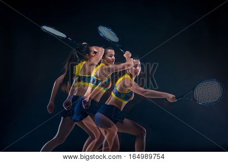 Portrait of beautiful girl tennis player with a racket on dark studio background. Stroboscope shooting technique