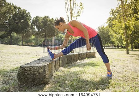 Beautiful woman doing stretching exercices in the park
