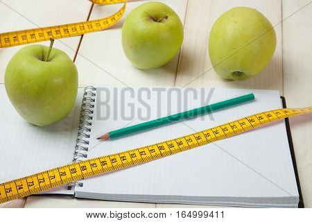 Green apple with measuring tape on white background