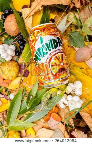 Saint-petersburg, Russia, 17 10 2018 Mirinda In A Glass Tin Bottle On Autumn Yellow Green Foliage Of