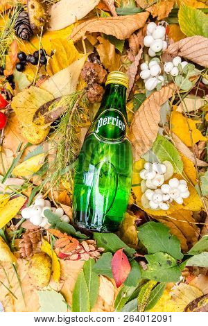 Saint-petersburg, Russia, 17102018 Perrier In A Glass Tin Bottle On Autumn Yellow Green Foliage Of T