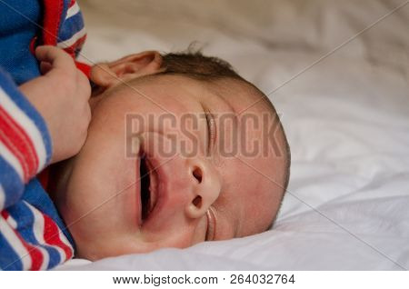 Two Weeks Old Newborn Baby Boy Smilin While Sleeping On White Quilt