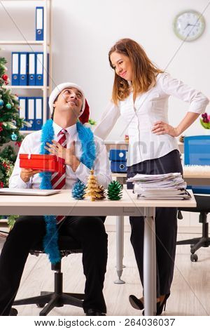 Colleagues exchaing christmas presents in office