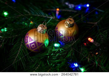 Christmas Toys - Golden Balls On A Christmas Tree Among Colorful Lights. Congratulations On The New 