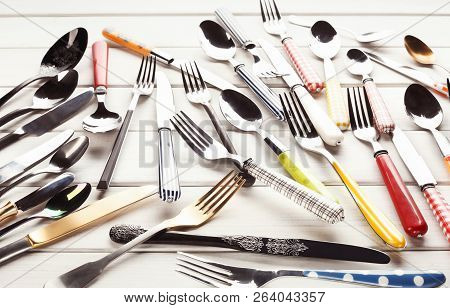 Various Forks, Knives And Spoons. Set Of Assorted Cutlery With Fancy Handles, Flat Lay On White Rust
