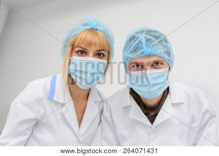 Two Doctors With Masck  In A Medical Office, Close View