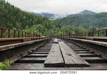 Railway Against Beautiful Mountainious Landscape. Colorful Horizon With Blue Sky, White Clouds, Moun