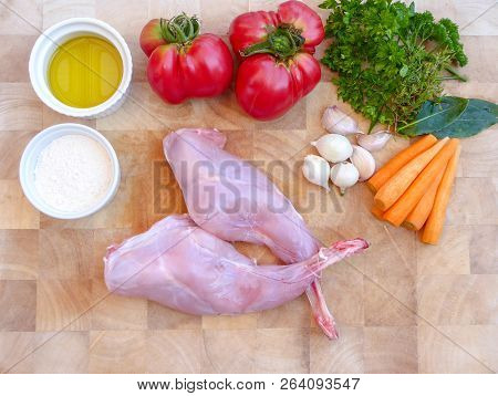 Background Of The Legs Of Rabbit Prepared For Cooking With Garlic, Thym, Carrot, Olive Oil, Red Toma