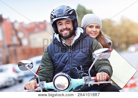 Portrait of happy couple with shopping bags after shopping in city
