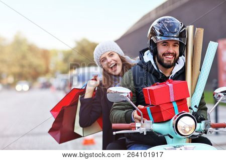 Portrait of happy couple with shopping bags after shopping in city