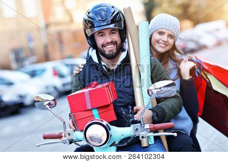 Portrait of happy couple with shopping bags after shopping in city