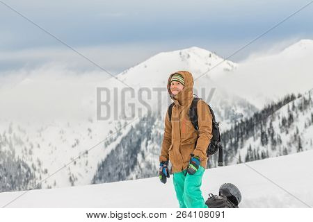 Snowboarder Girl Freerider Is Standing In The Snowy Mountains In Winter Under The Clouds