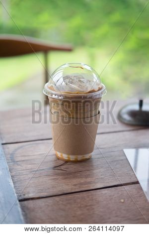 Ice Caramel Mochiato Put On Wooden Table In Coffee Shop