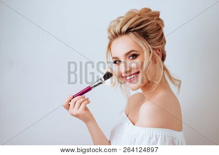 Fashion Glamour Portrait Of Happy Smiling Blonde Woman Long Wavy Hair Style Holding Brush Over Light