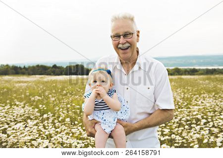 Grandfather Spending Time With Little Child During The Sunset.