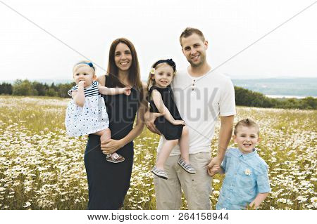 Family Spending Time With Little Child During The Sunset.