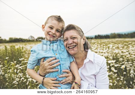 Grandmother Spending Time With Little Child During The Sunset.