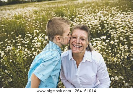 Grandmother Spending Time With Little Child During The Sunset.