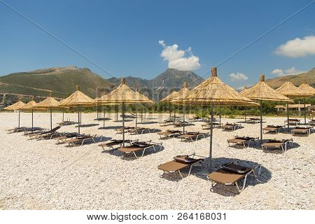 Umbrellas On The Borsh Beach In Albania. Stony Beach On The Adriatic Sea.