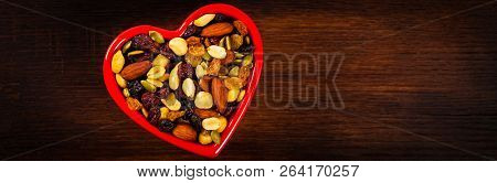 Energy Blend Trail Mix With Nuts And Dried Fruits In Heart Shaped Bowl. Selective Focus.