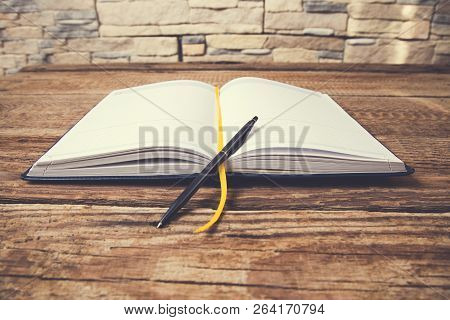 Pen On Notepad On Vintage Wooden Table