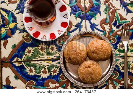 Turkish Dessert Kemalpasa With Tea On A Ottoman Pattern Surface.
