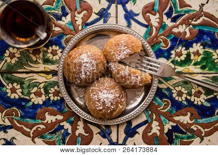 Turkish Dessert Kemalpasa With Tea On A Ottoman Pattern Surface.