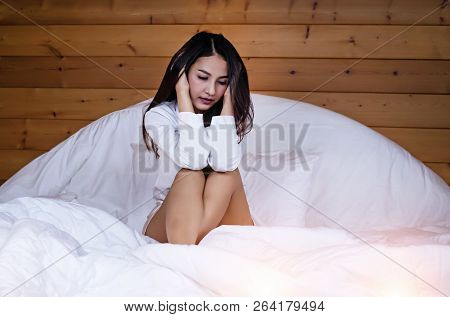The Beautifu Laday Is Sitting On Bed,put Her Hand Touch Head,unhappy Feeling,headache From Tried And