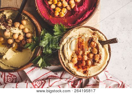 Different Hummus Bowls. Chickpea Hummus, Avocado Hummus And Beet Hummus. Plant Based Diet Food.