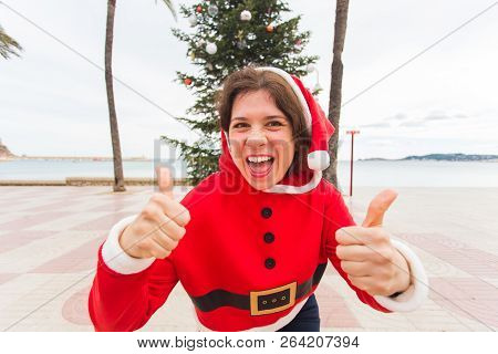 Christmas, Holidays, Humor And People Concept- Young Happy Woman In Christmas Suit At Summer Showing